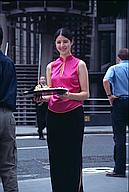 Girl handing out flyers promoting a singaporean restaurant